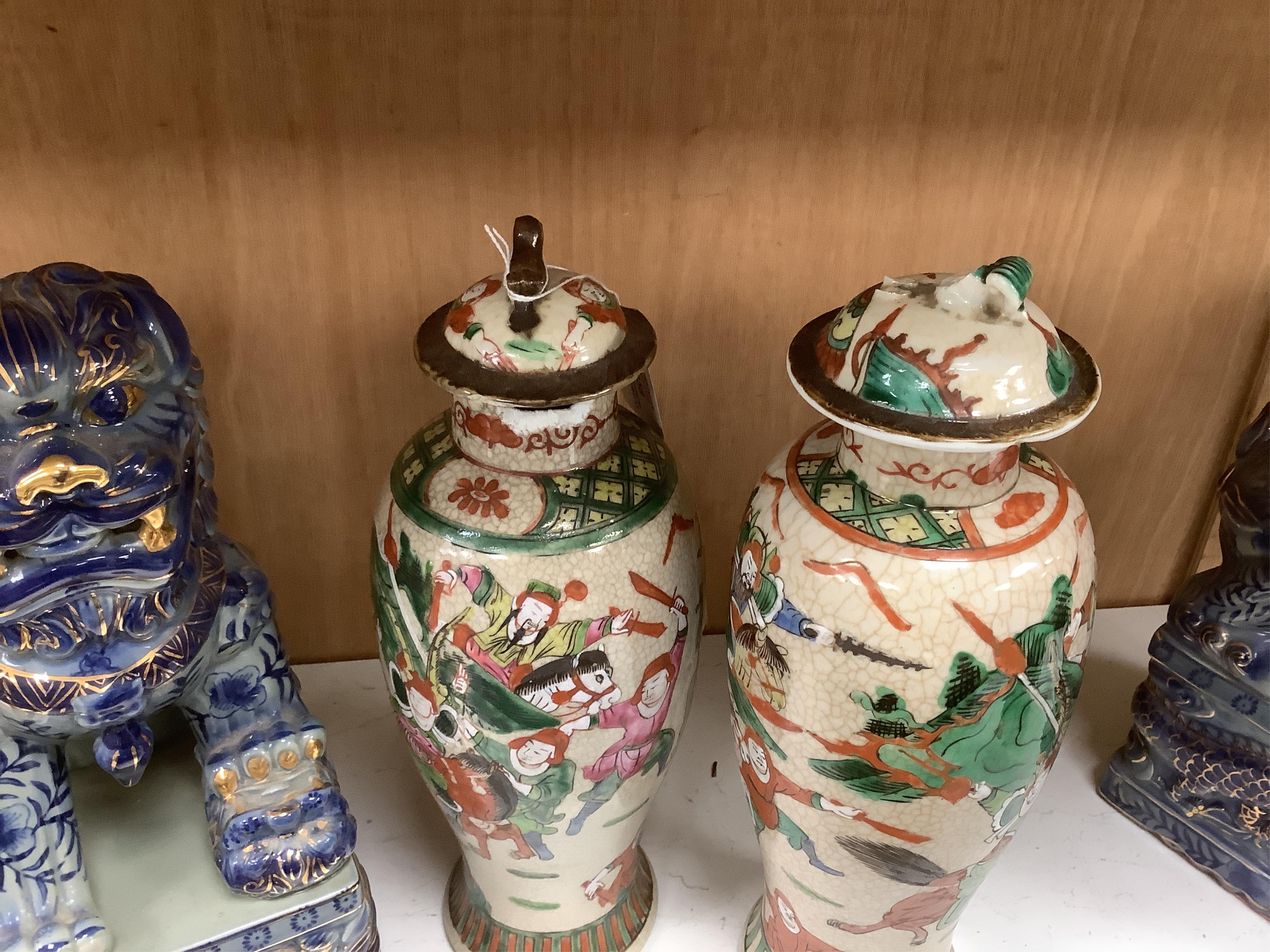 A group of Chinese ceramics including a large blue and white sleeve vase, circa 1900, two crackle glazed vases and covers, similar jar, a prunus jar and a pair of lion dogs, largest 36cm (7). Condition - poor to fair